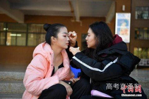 资料图:2020年1月11日,考场外一名女孩在补妆。当日,云南艺术学院2020年艺术类本科招生表演类专业校考大幕拉开。中新社记者 刘冉阳 摄
